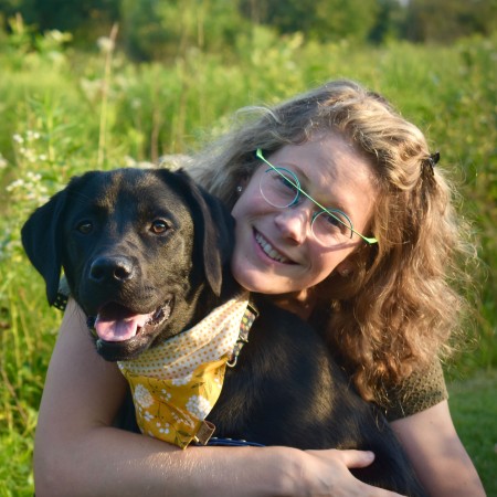 Headshot of Sarah-Elizabeth Byosiere with Sadie the black Labrador/Golden Retriever Cross